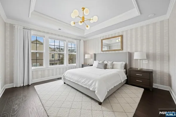 a spacious bedroom with a large bed and a chandelier
