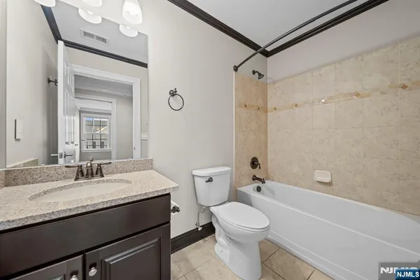 a bathroom with a granite countertop sink mirror vanity and toilet