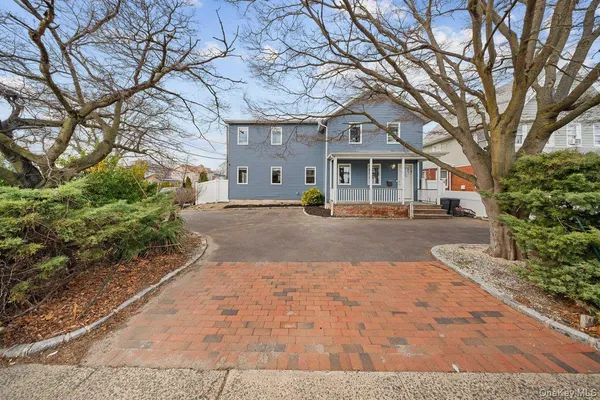 a front view of a house with a yard and potted plants