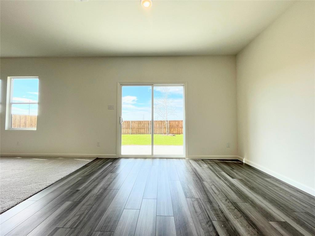 1702 Chapel Hl Road Princeton, TX 75407 - Photo 8 of 24 an empty room with wooden floor and windows