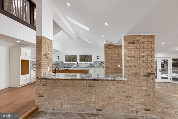 a bedroom with a large bed couch and a potted plant