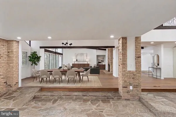 a view of an empty room with wooden floor and windows