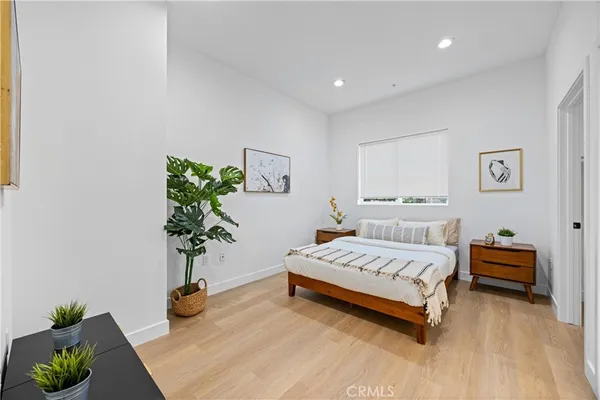 a bedroom with a bed and a potted plant