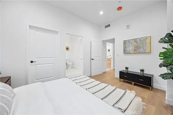 a bedroom with a bed and a potted plant