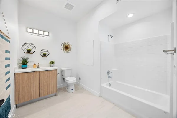 a bathroom with a granite countertop toilet and a bathtub