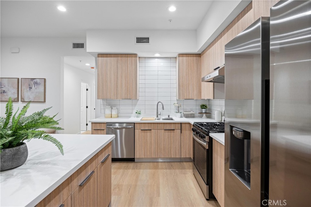 13857 Leffingwell Road Whittier, CA 90604 - Photo 18 of 32 a kitchen with a sink stove and refrigerator