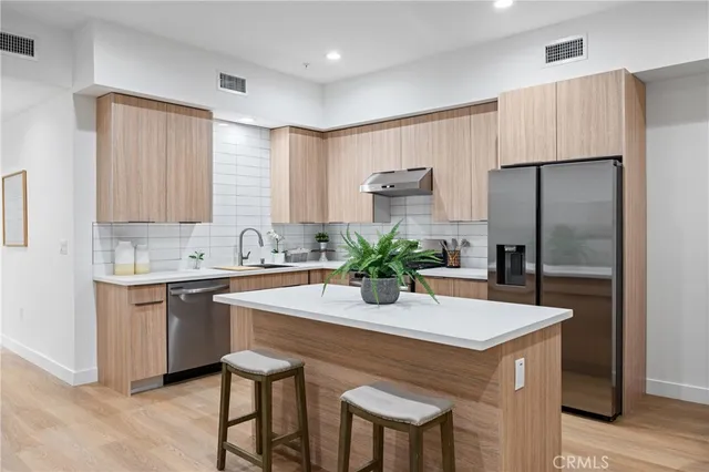 a kitchen with stainless steel appliances a sink and a refrigerator