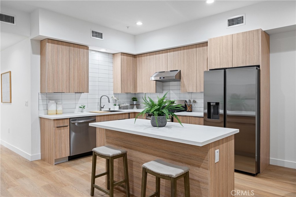 13857 Leffingwell Road Whittier, CA 90604 - Photo 20 of 32 a kitchen with stainless steel appliances a sink and a refrigerator