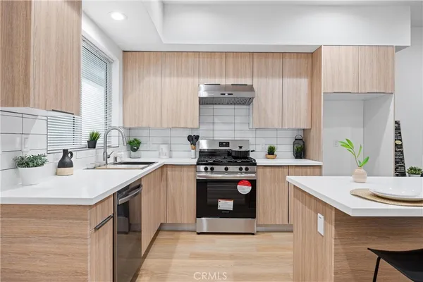 a kitchen with kitchen island granite countertop a sink appliances cabinets and counter space