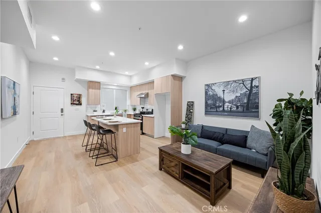 a living room with furniture and a dining table with kitchen view