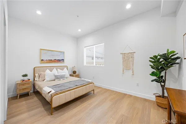 a bedroom with a bed and a potted plant