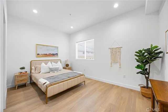a bedroom with a bed and a potted plant