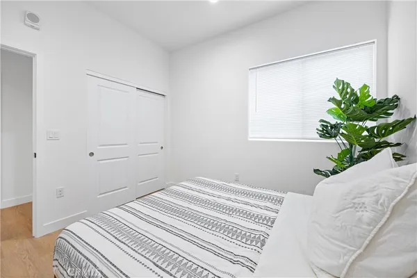 a bedroom with a bed and a potted plant
