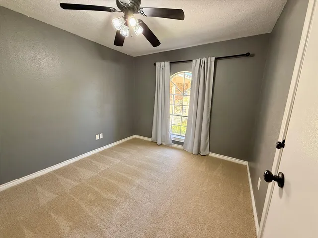 an empty room with a fan and a fan