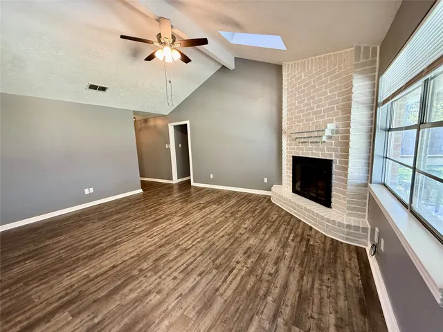 a view of an empty room with a fireplace and a window