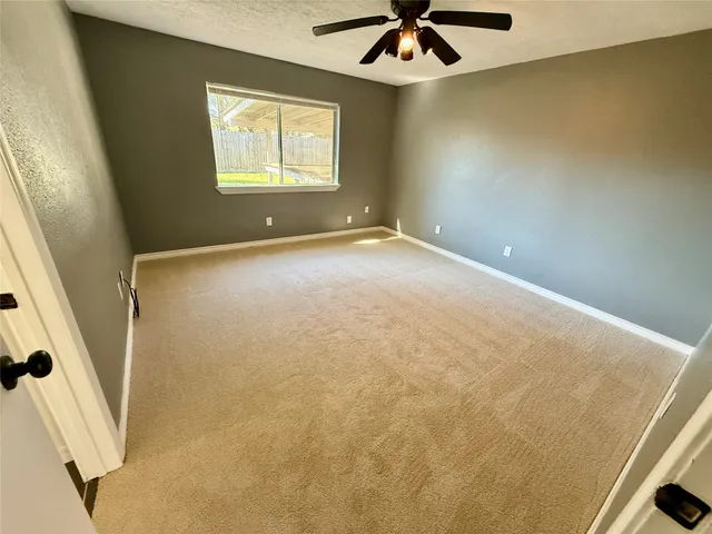 a view of a livingroom with a ceiling fan and window