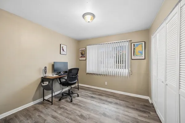 a workspace with wooden floor and a window