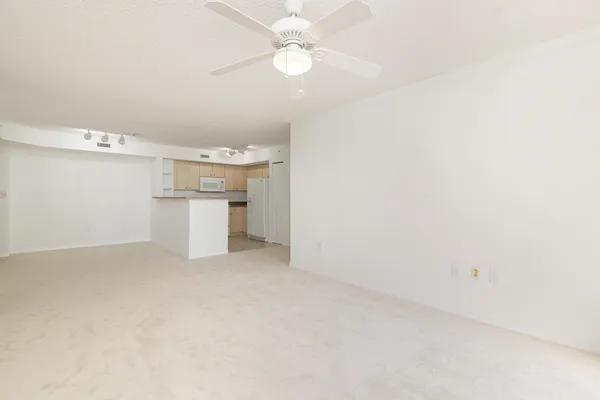 an empty room with a cabinet and a chandelier fan