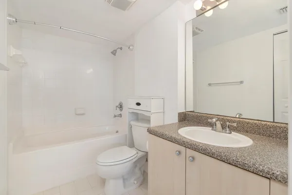 a bathroom with a granite countertop sink toilet and shower