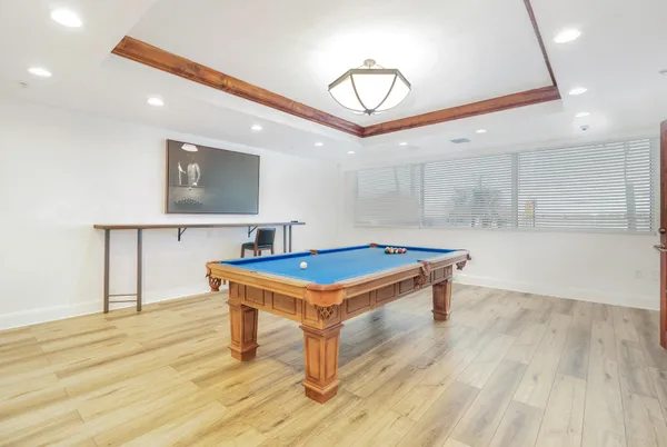 a room with wooden floor and pool table
