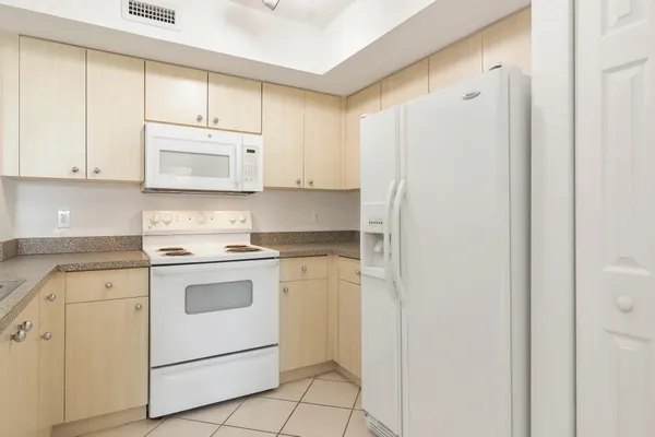 a kitchen with white cabinets and white appliances