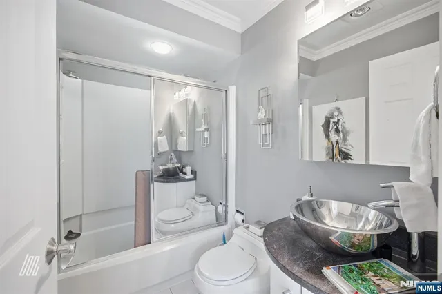 a bathroom with a granite countertop sink a toilet and shower