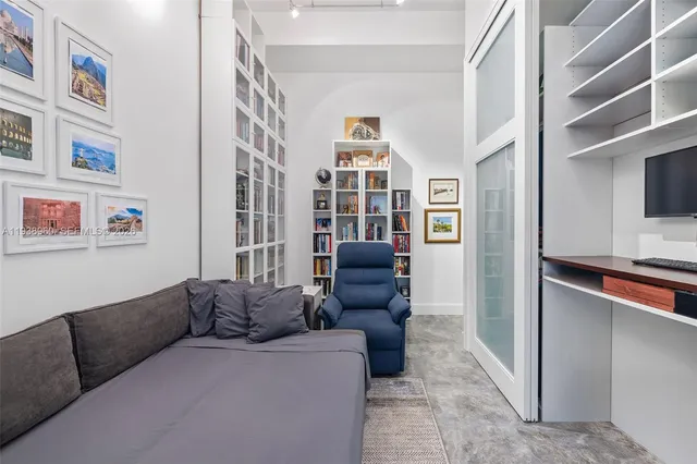 a living room with furniture a rug and a bookshelf