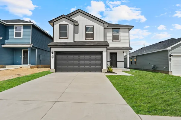 a front view of a house with a yard and garage