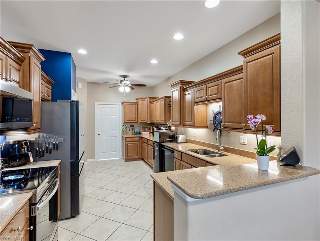 20026 Larino Loop Estero, FL 33928 - Photo 15 of 48 a kitchen with stainless steel appliances granite countertop a sink and a refrigerator