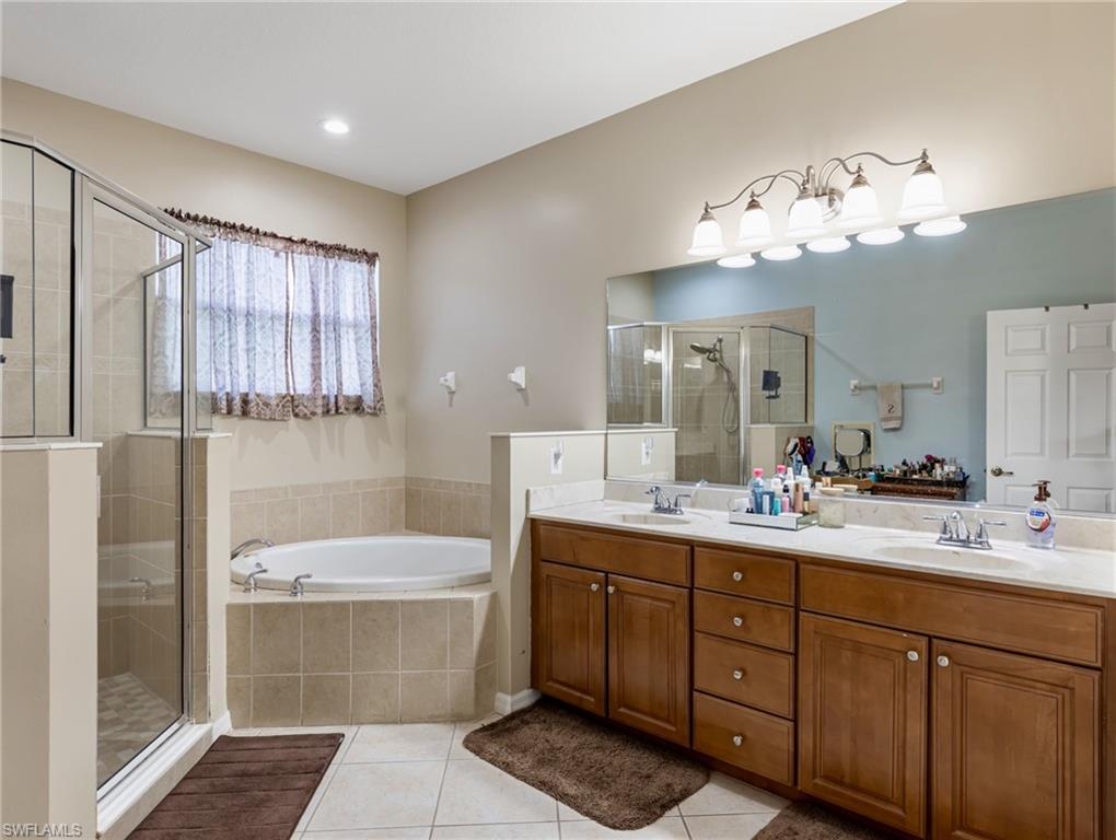 20026 Larino Loop Estero, FL 33928 - Photo 28 of 48 a bathroom with a double vanity sink a large mirror and a bathtub