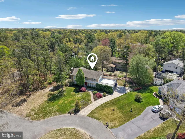 an aerial view of a house with a garden and lake view
