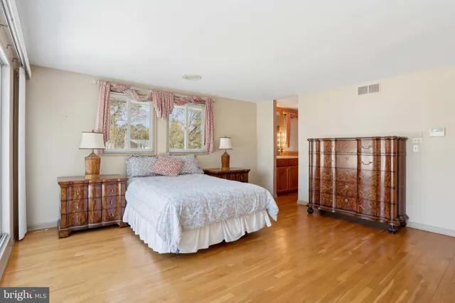 a bathroom with a granite countertop sink a toilet a mirror and window