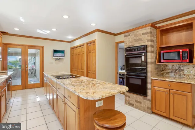 a room with kitchen island granite countertop lots of clutter and stainless steel appliances