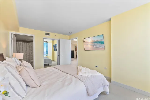 a bedroom with a bed and painting on the wall