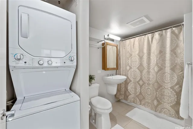 a white toilet sitting next to a bathroom sink and a shower