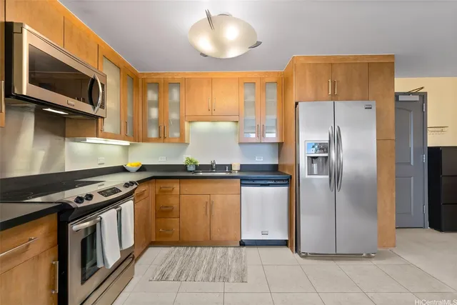 a kitchen with stainless steel appliances granite countertop a refrigerator a stove and a sink