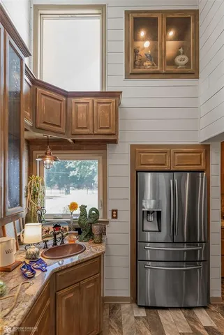 a kitchen with kitchen island granite countertop a refrigerator stove and sink