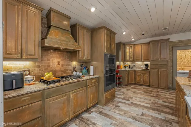 a kitchen with stainless steel appliances granite countertop a sink a stove and a refrigerator