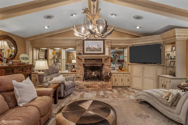 a living room with furniture a fireplace and a flat screen tv