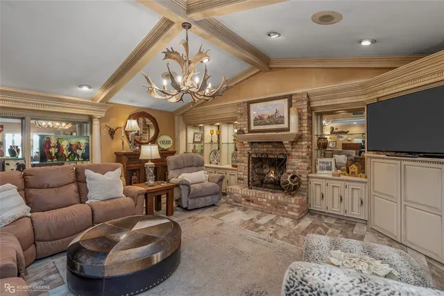 a living room with furniture a fireplace and chandelier