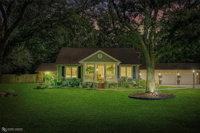 a front view of a house with a yard and trees