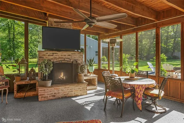 a living room with furniture a fireplace and a floor to ceiling window