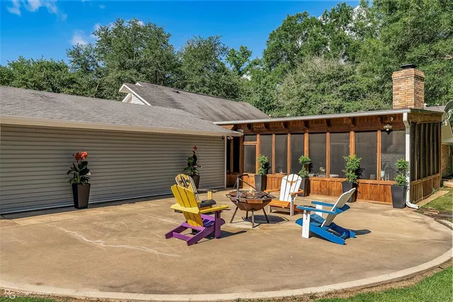 a view of backyard with seating space and wooden fence