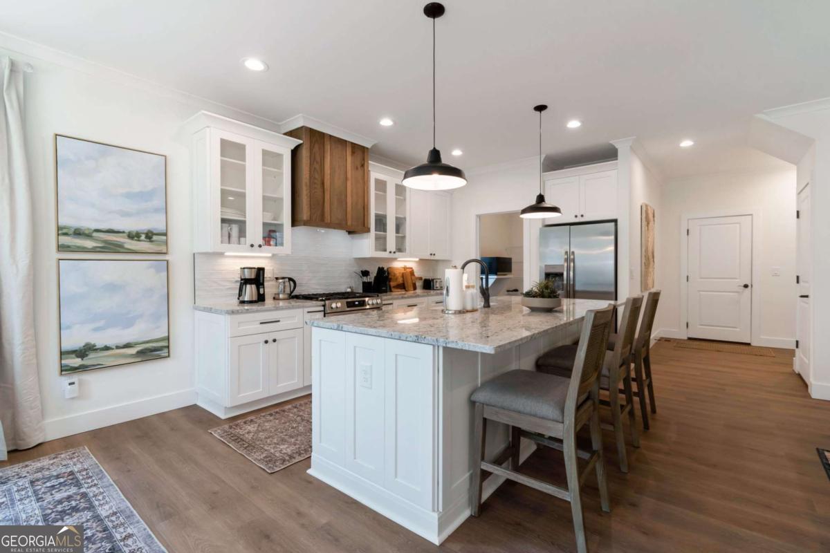 629 Butterworth Road Canton, GA 30114 - Photo 4 of 27 a kitchen with stainless steel appliances granite countertop a stove a refrigerator a sink a dining table and chairs with wooden floor