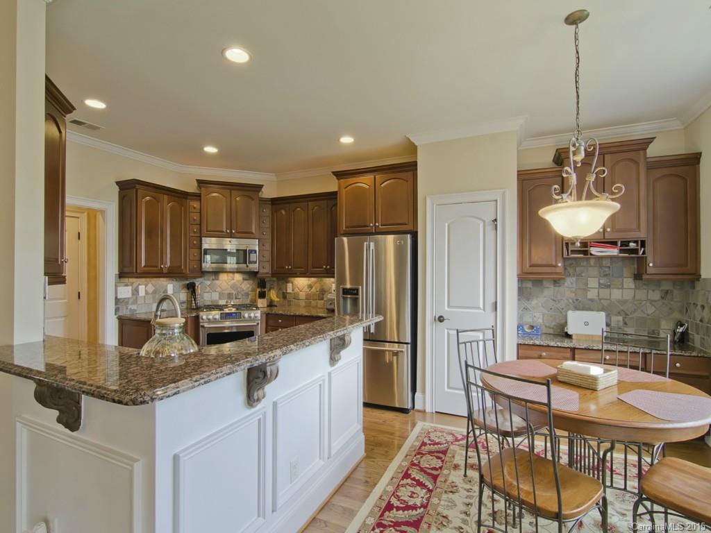 6729 Fox Ridge Circle Davidson, NC 28036 - Photo 2 of 24 a kitchen with stainless steel appliances granite countertop a sink a stove a refrigerator cabinets and chairs