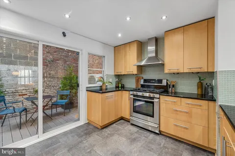 a kitchen with stainless steel appliances granite countertop a stove a sink and a refrigerator