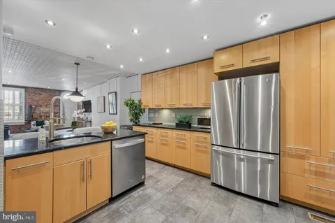 a kitchen with stainless steel appliances granite countertop a refrigerator sink and cabinets