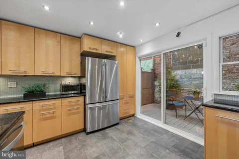 a kitchen with stainless steel appliances granite countertop a refrigerator and a stove top oven
