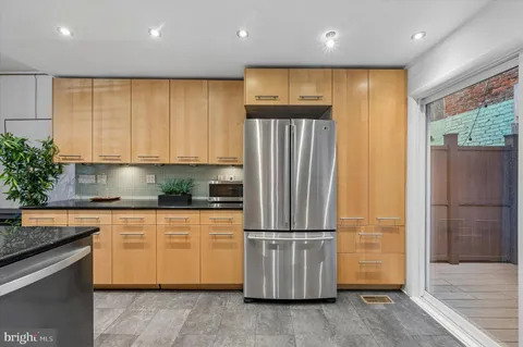 a kitchen with stainless steel appliances granite countertop a refrigerator a sink and a stove