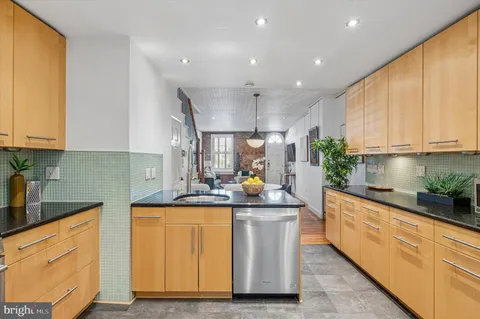 a kitchen with stainless steel appliances granite countertop a sink a stove and a refrigerator
